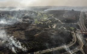 Aerial view of palms and brush burning at Real Del Mar residential outskirts Tijuana, Baja, California state.