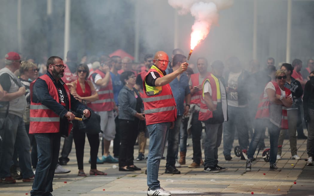 A man holds a flare as people demonstrate in Le Havre northwestern France.