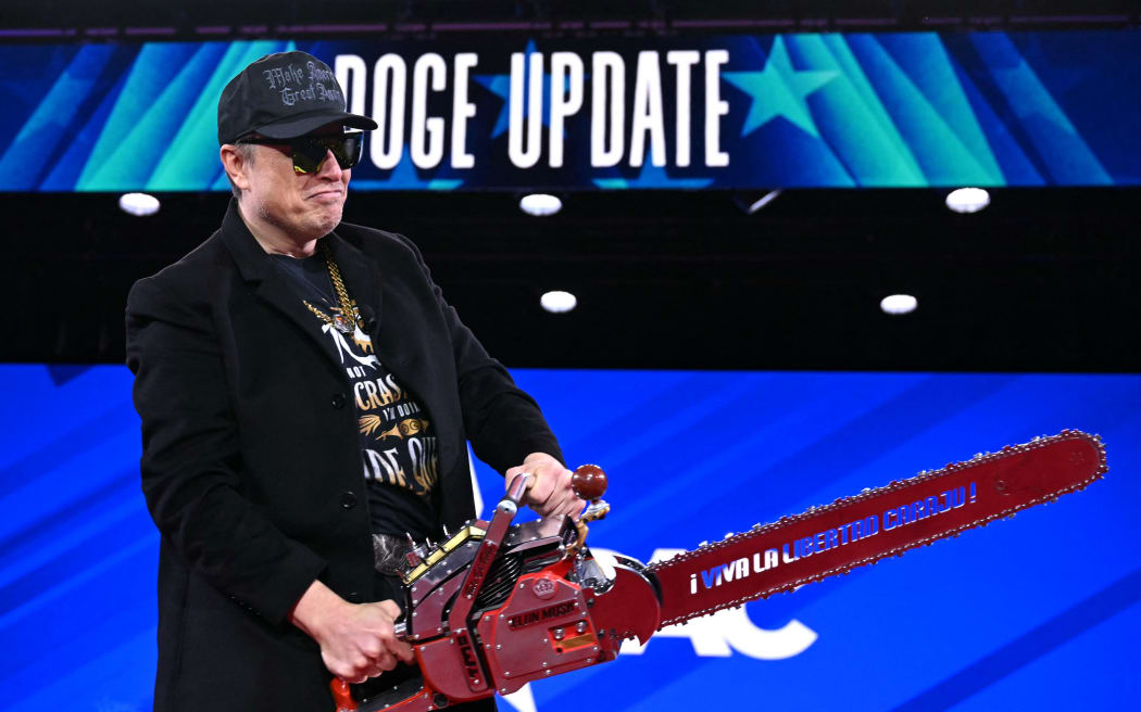 Elon Musk holds a chainsaw reading "Long live freedom, damn it" during the annual Conservative Political Action Conference (CPAC) at the Gaylord National Resort & Convention Center at National Harbor in Oxon Hill, Maryland, on February 20, 2025. The chainsaw was a present to Elon Musk from Argentina's President Javier Milei. (Photo by SAUL LOEB / AFP)