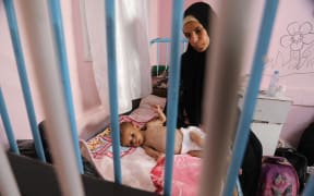 Maryam, a 26-year-old Palestinian mother, cradles her malnourished 40-day-old son Mahmoud as they await treatment at the Nasser hospital in Khan Yunis in the southern Gaza Strip on July 24, 2025. More than 100 aid organisations and human rights groups warned on Wednesday that "mass starvation" was spreading in Gaza, as the United States said its top envoy was heading to Europe for talks on a possible ceasefire and aid corridor.