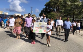 Hundreds of people marched in Majuro, capital of the Marshall Islands, on March 1 to mark the 70th anniversary of the Bravo hydrogen bomb test at Bikini Atoll, including Foreign Minister Kalani Kaneko (left center) and Pacific Islands Forum Secretary General Henry Puna (next to Kaneko). Photo: Wilmer Joel.