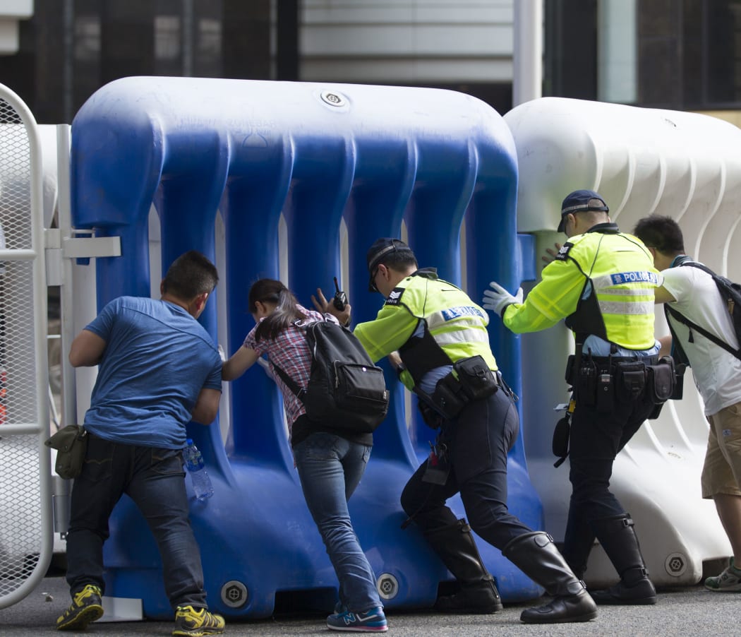Police officers seal the roads with water-filled barricades in downtown Wanchai.
