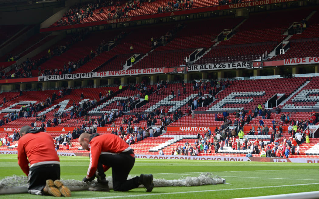 Fans leave the Sir Alex Ferguson stand during the evacuation of both the Stretford End stand (unseen) and the Alex Ferguson stands ahead of the English Premier League football match between Manchester United and Bournemouth at Old Trafford in Manchester, north west England, on May 15, 2016.