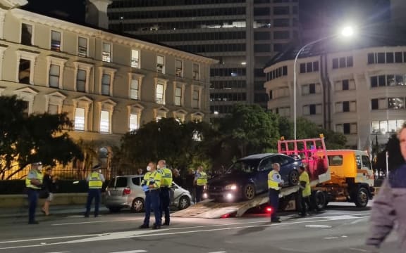 Police at the scene as a vehicle is towed late Wednesday night, near Parliament.