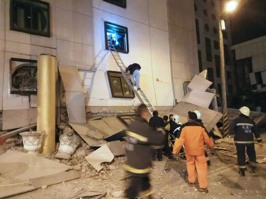 Rescue workers search through rubble outside the Marshal Hotel in Hua-lien