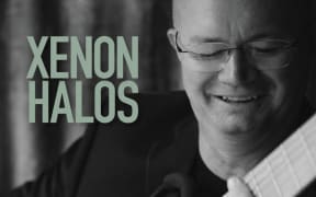 Matthew Marshall plays his classical guitar on the black and white cover of his new album, Xenon Halos.
