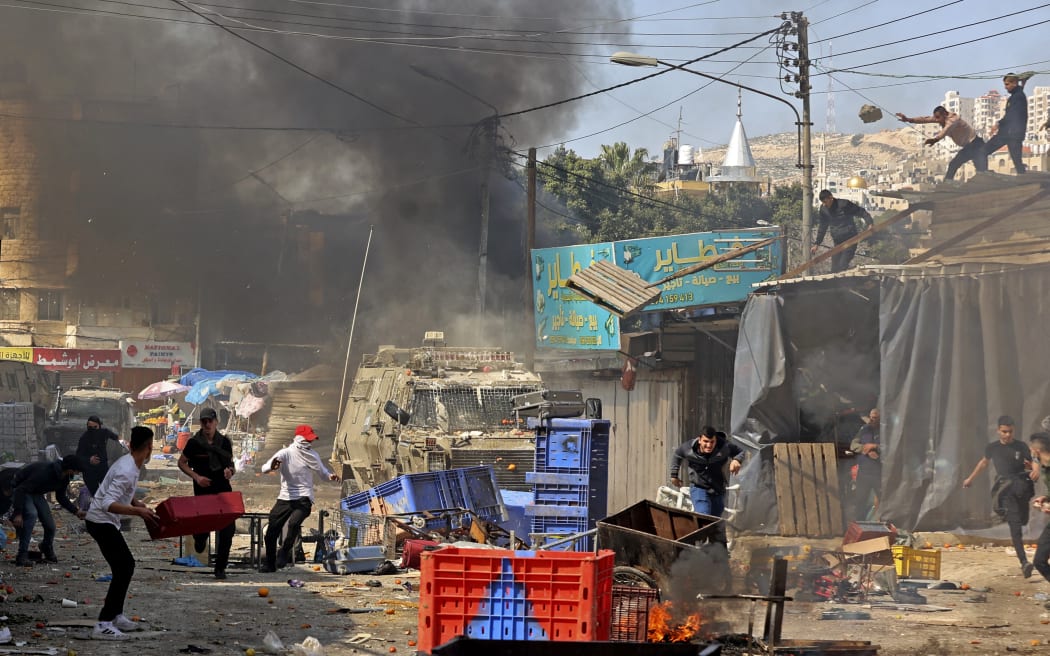 Palestinians clash with Israeli security forces during a raid in the occupied West Bank city of Nablus, on February 22, 2023.