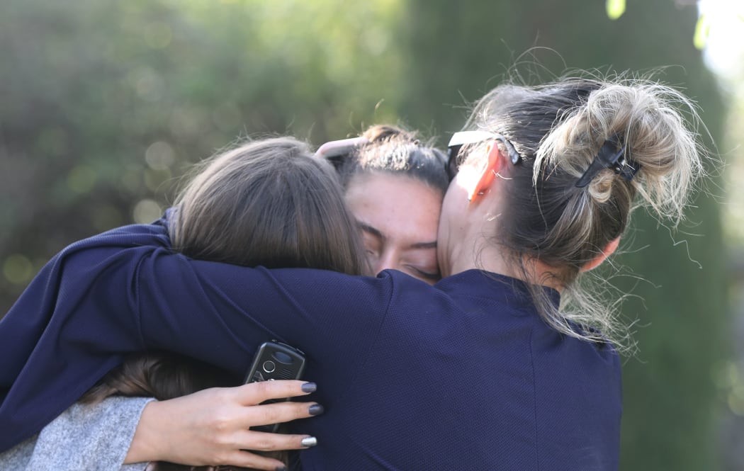 People react near the Tocqueville high school in the southern French town of Grasse, on March 16, 2017 following a shooting that left two people injured.