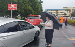 People queue for a Covid-19 test at Taranaki Base Hospital, where a line of cars hundreds of metres long snaked along Tukapa Street.