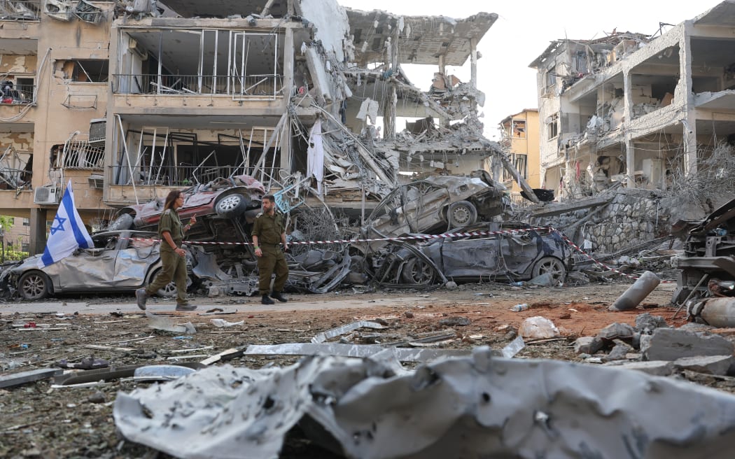 Israeli soldiers inspect a site hit by a missile fired from Iran in the Israeli city of Ramat Gan near Tel Aviv on June 14, 2025. Iran struck Israel early June 14, with barrages of missiles after a massive onslaught targeted the Islamic republic's nuclear and military facilities, and killed several top generals. (Photo by Jack GUEZ / AFP)