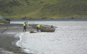 Locals and Landsar personnel at the Marokopa River estuary during the search for Thomas Phillips and his children.