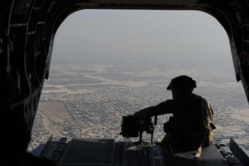 A file photo of a soldier in a helicopter flying over Kabul.