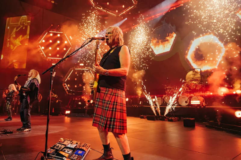 Still from Spinal Tap II: The End Continues showing Nigel Tufnell (Christopher Guest) on stage wearing a kilt.