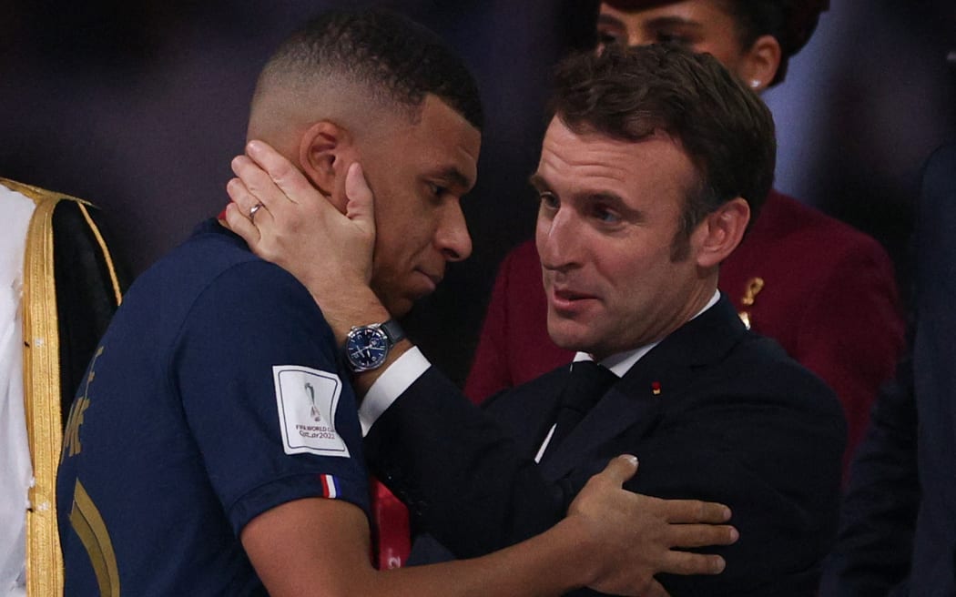 French President Emmanul Macron, right, hands the FIFA Golden Boot award to France's forward #10 Kylian Mbappe, left, during the trophy ceremony at the end of the Qatar 2022 World Cup final football match between Argentina and France at Lusail Stadium in Lusail, north of Doha on December 18, 2022.