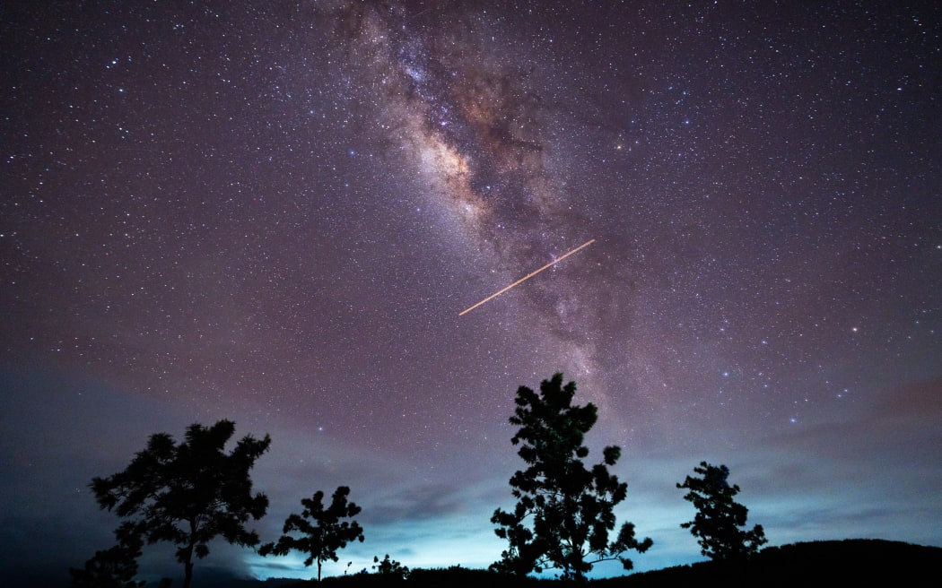 A flight-illuminated path and the Milky Way are appearing in the night sky during the Eta Aquarids meteor shower, which is peaking in Ratnapura, Sri Lanka, on May 5, 2024. The Eta Aquarids Meteor Shower is an annual event caused by Earth passing through debris left behind by Halley's Comet. Named after the constellation Aquarius, these meteors are streaking across the sky at high speeds, creating a dazzling display of shooting stars. Best observed in the predawn hours away from city lights, it is a mesmerizing celestial event cherished by skywatchers worldwide. (Photo by Thilina Kaluthotage/NurPhoto) (Photo by Thilina Kaluthotage / NurPhoto / NurPhoto via AFP)