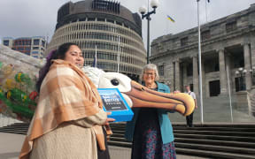 Greenpeace plastics campaigner Juressa Lee presents petition to Green MP Eugenie Sage signed by 100,000 people calling on the government to ban single-use plastic bottles on 30 June 2022.