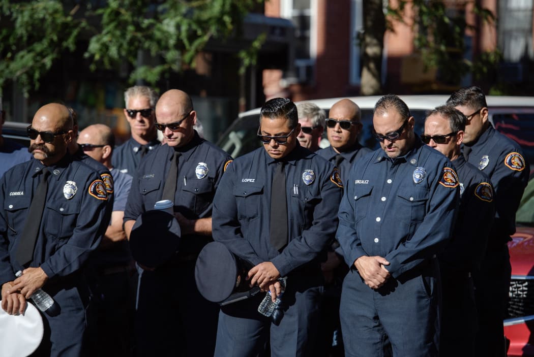 Firefighters take part in a moment of silence on the 20th anniversary of the 9/11 attacks on the World Trade Center in New York, on September 11, 2021.