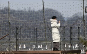 A visitor looks over a military fence on a viewing deck at Imjingak peace park, near the Demilitarised Zone (DMZ) dividing the two Koreas in Paju on 1 January 2020.
