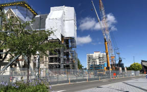 Scaffolding and a crane in front of a building being repaired in a central Christchurch street