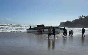 Rescuers came to the add of a capsized yacht on Sandy Bay Beach in Northland.