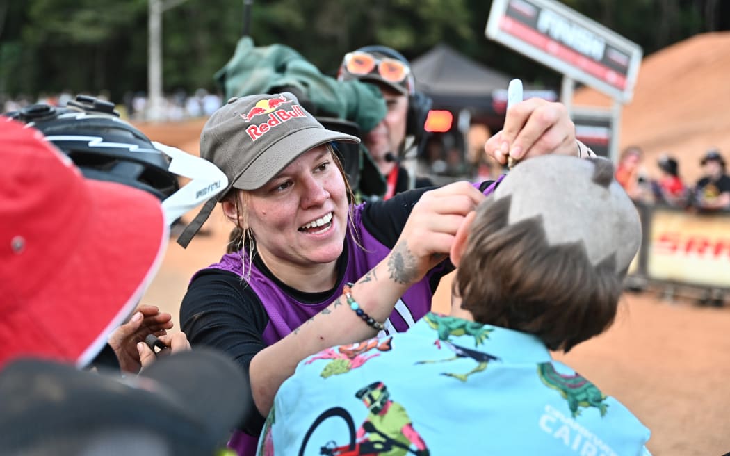 Harriet Burbidge-Smith signs an autograph after winning the Pro female Dual Slaom during 2023 Crankworx Cairns.
