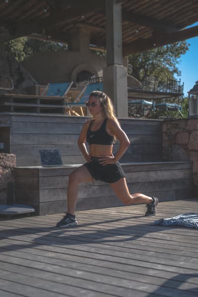 A woman performing a lunge exercise.