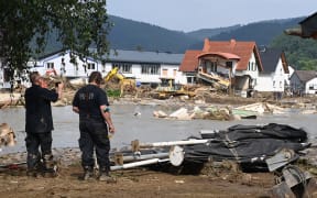 A worker takes a picture of a destroyed area in Insul near Bad Neuenahr-Ahrweiler, western Germany.