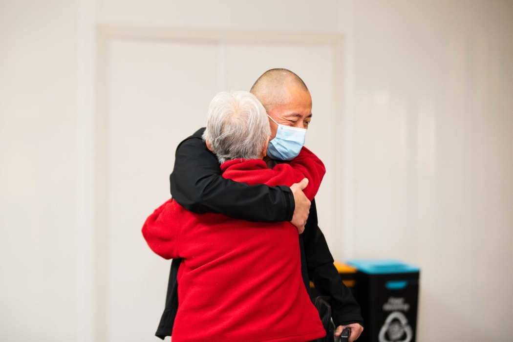 A hug for a passenger on the first flight from Sydney to Auckland Airport under the trans-Tasman bubble arrangement.