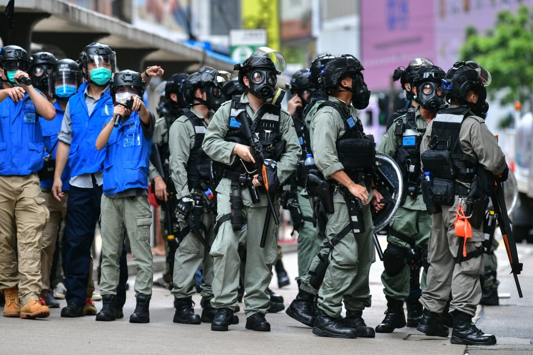 Riot police gather on a road as protesters take part in a pro-democracy rally