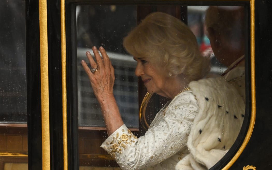 Britain's Camilla, Queen Consort waves from the Diamond Jubilee State Coach, during the 'King's Procession', a journey of two kilometres from Buckingham Palace to Westminster Abbey in central London on May 6, 2023, ahead of their coronations. - The set-piece coronation is the first in Britain in 70 years, and only the second in history to be televised. Charles will be the 40th reigning monarch to be crowned at the central London church since King William I in 1066. Outside the UK, he is also king of 14 other Commonwealth countries, including Australia, Canada and New Zealand. Camilla, his second wife, will be crowned queen alongside him and be known as Queen Camilla after the ceremony. (Photo by SEBASTIEN BOZON / POOL / AFP)