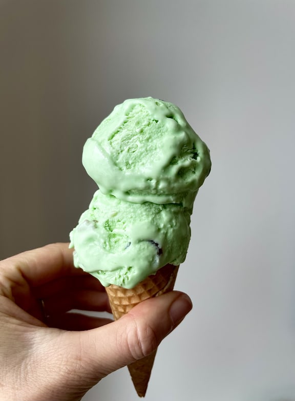 Homemade Goody Gumdrop Ice Cream - a close up of a hand holding a cone topped with two scoops