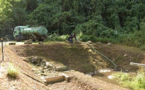 Truck moving sludge from Rarotonga water treatment site to dump at Papua