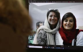 A woman looks at a picture of Iranian reporters Niloufar Hamedi and Elahe Mohammadi posted on twitter, in Nicosia on November 2, 2022. Concern is growing over the fate of the two Iranian reporters who helped bring the world’s attention to the death of Mahsa Amini but have been jailed for the past month and are now targeted by what activists see as a smear campaign to portray them as spies. (Photo by Christina ASSI / AFP)