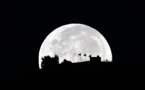 The super blue moon is pictured over Nablus on August 31, 2023. (Photo by Zain JAAFAR / AFP)