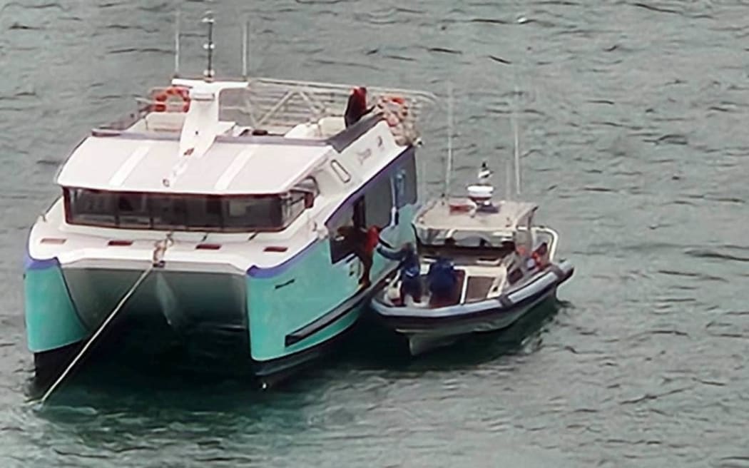 The East by West ferry apparently lost power while transporting passengers. Pictured, police help tow the boat back to Queens Wharf.