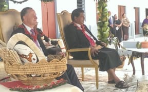 New Zealand Prime Minister John Key and Tongan PM Lord Tu'ivakano, with a basket of gifts presented by school children from Nuku'alofa Primary School.