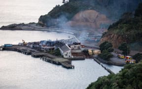 Fire crews dampen down the site of a blaze in a warehouse at Shelly Bay, Wellington.