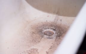A clogged dirty drain in the bathroom for water