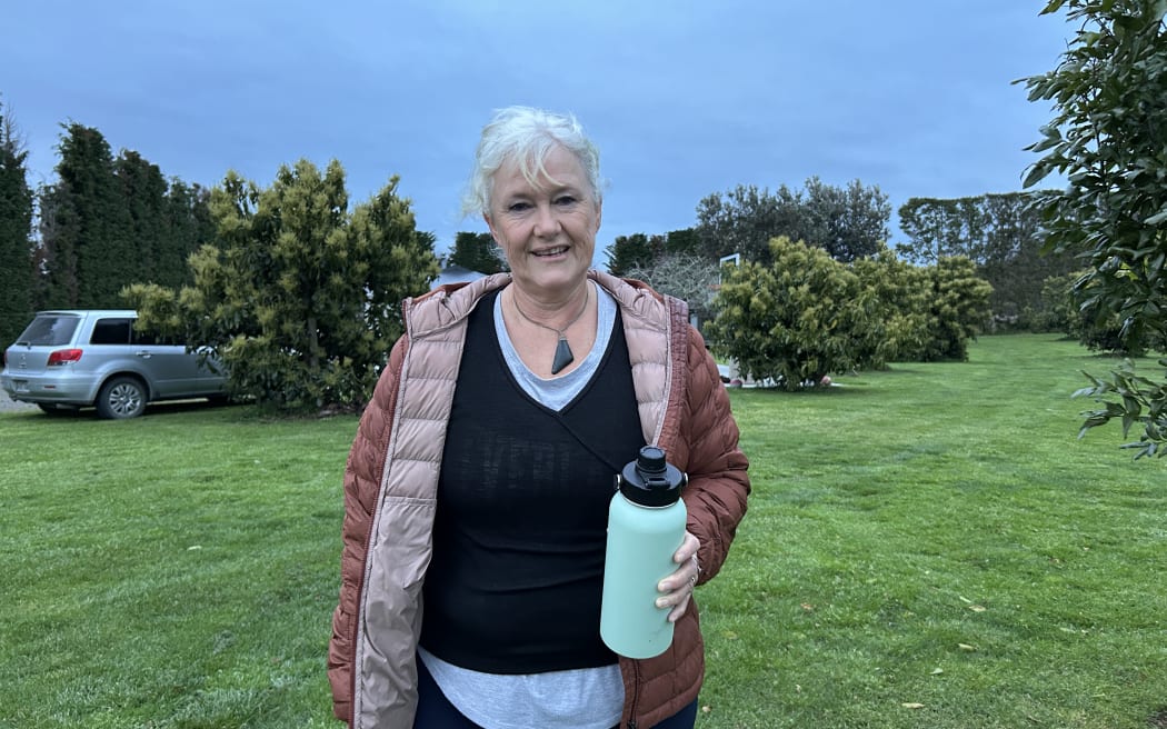 Portrait of a woman in front of avocado trees.