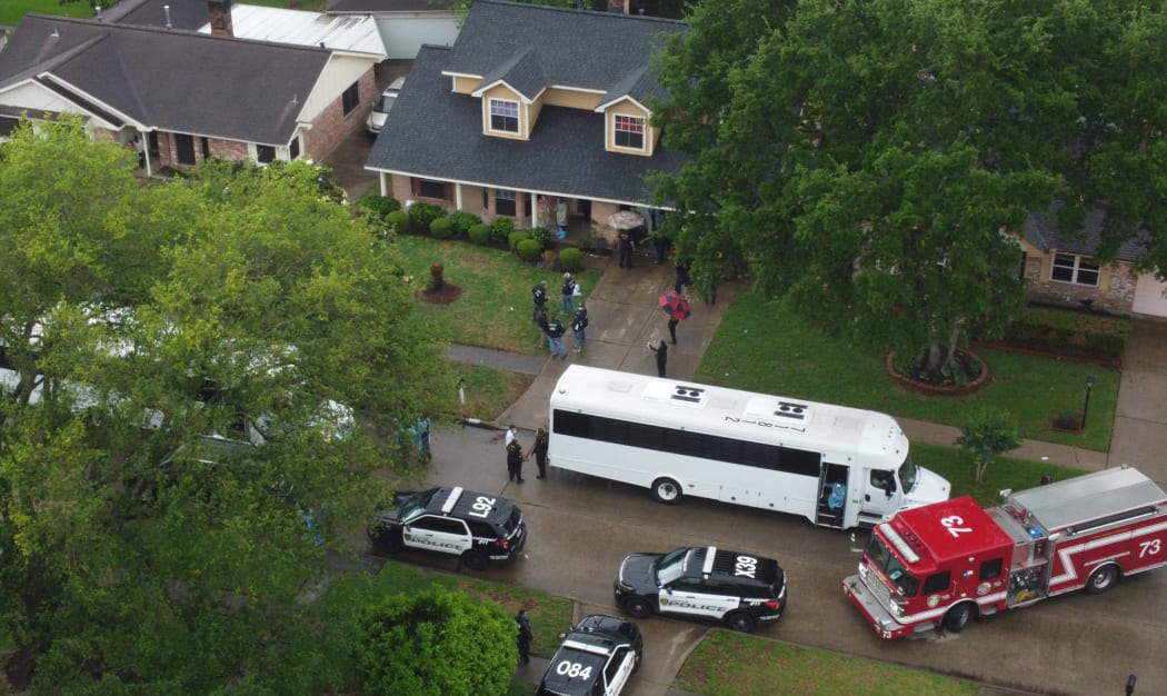 This aerial photo shows police activity around a house where more than 90 people were found crammed together in Houston, Texas