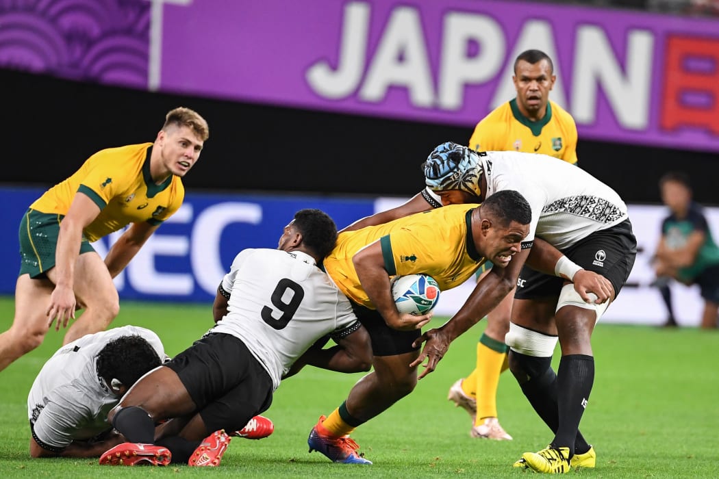 Australian prop Scott Sio tries to bust through the tackle in the World Cup match against Fiji.