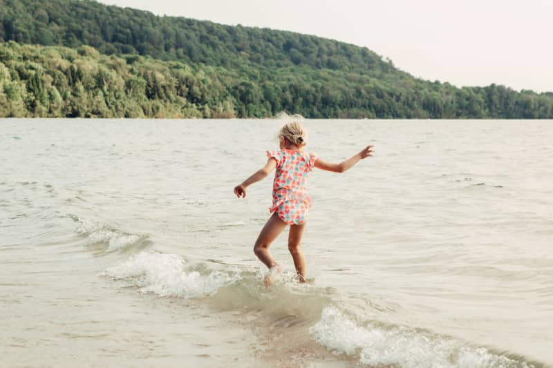 Child playing in water on beach.