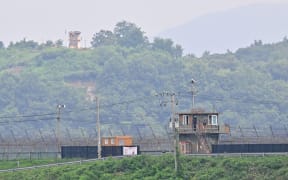 A North Korean guard post (top) on the Korean Demilitarized Zone (DMZ), is seen over a South Korean military fence (bottom) from the border city of Paju on July 19, 2023. A US soldier who served around two months in a South Korean jail on assault charges was believed to be in North Korean custody on July 19, after crossing the heavily fortified border without authorisation, officials said. (Photo by Jung Yeon-je / AFP)