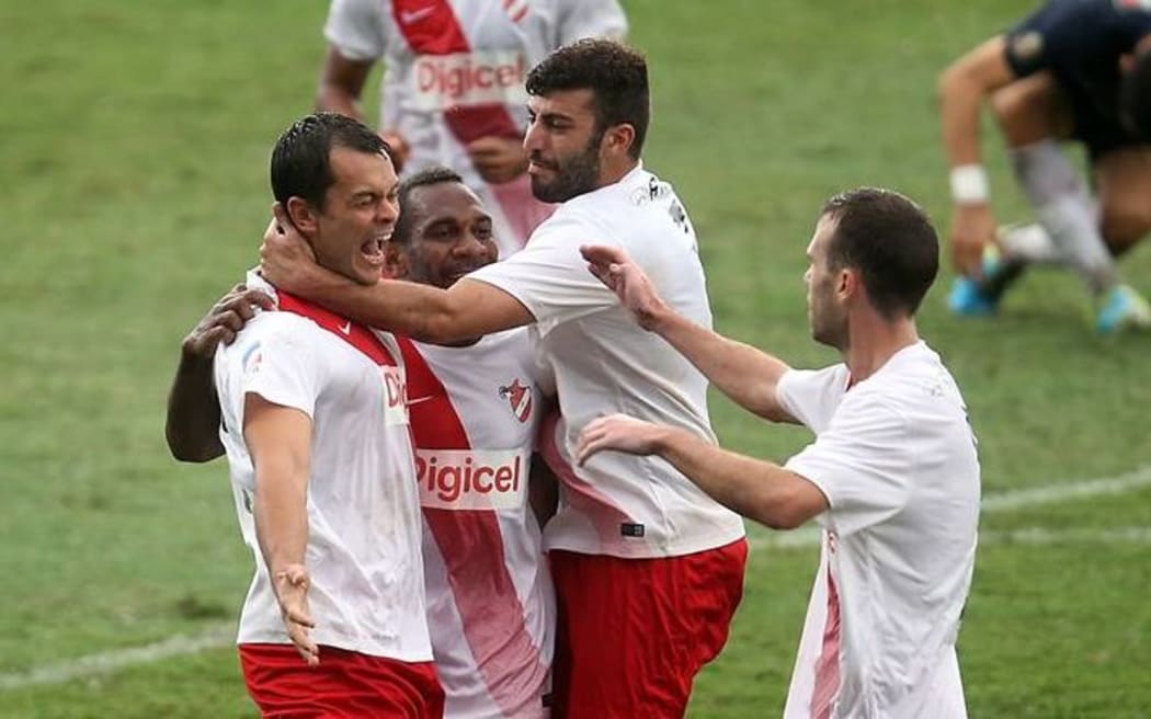 Amicale's Adam Dickinson celebrates with teammates after scoring the opening goal of the match.