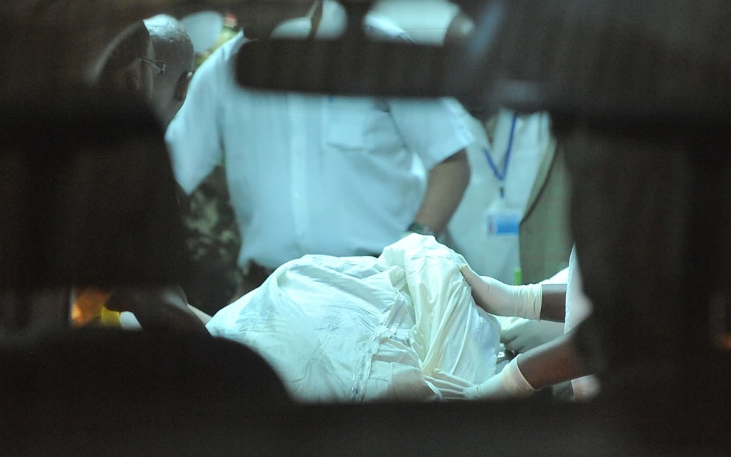 A morgue attendant receives bodies of the victims killed in a dawn attack on a bus in Kenya.
