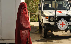 A woman walks past a Red Cross vehicle in Kabul (file photo).