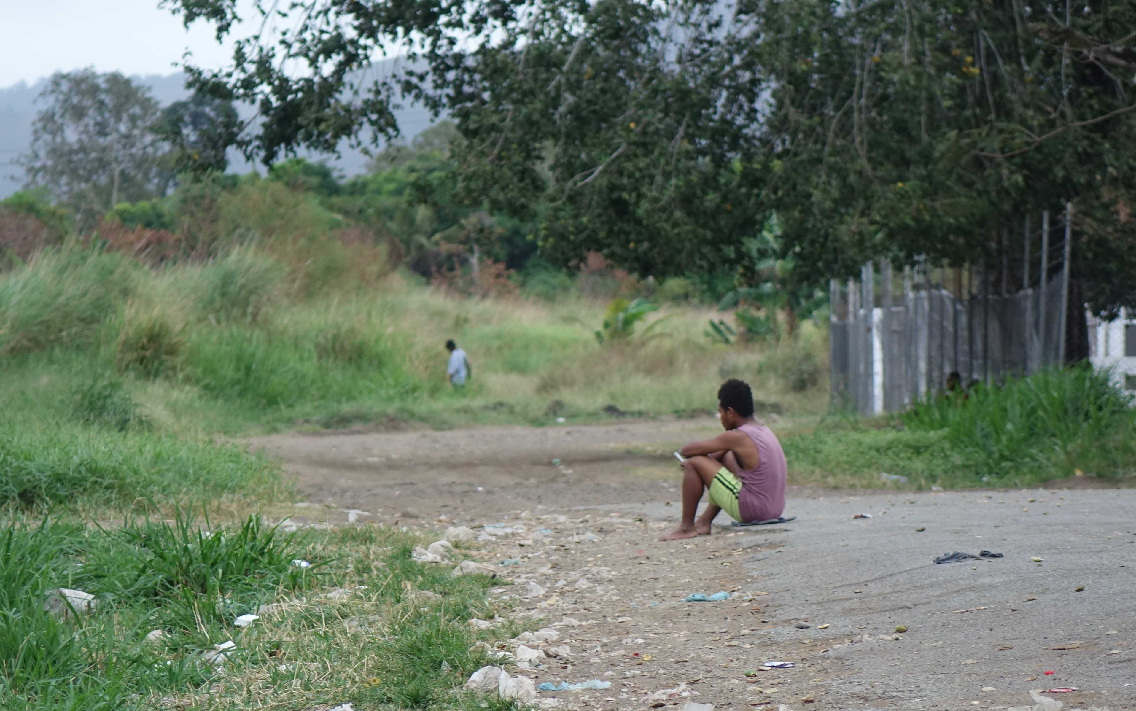 Aimless youth: a young Papua New Guinea man sits on the ground in Kwikila.