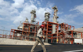 An Iranian employee walks at the phase 15-16 of the South Pars gas field facilities in the southern Iranian port town of Assaluyeh on the shore of the Gulf on November 19, 2015. AFP PHOTO / ATTA KENARE (Photo by Atta KENARE / AFP)