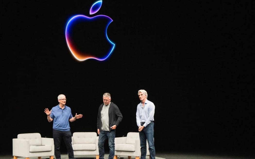 Apple CEO Tim Cook (L), John Giannandrea (C), senior VP of machine learning and AI strategy and Craig Federighi (L), senior VP software engineering, speak  during Apple's annual Worldwide Developers Conference (WDC) in Cupertino, California on June 10, 2024. (Photo by Nic Coury / AFP)