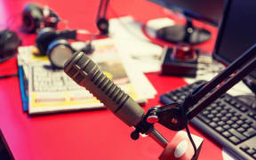 technology, electronics and audio equipment concept - close up of microphone at recording studio or radio station
